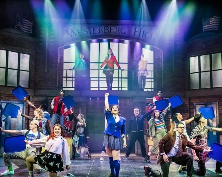 A group of people in a school setting with a sign reading 'WESTERBURG HIGH' above them. 3