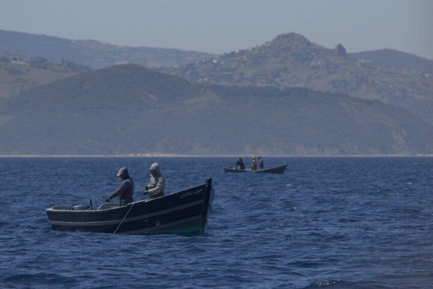 Two boats on calm water with a hilly landscape in the background. 2