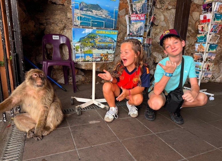 A monkey, two children, a map stand, and a sign reading 'GIBRALTAR'. 5