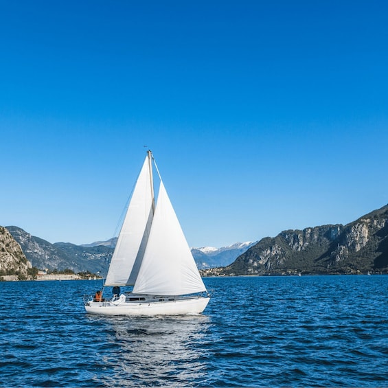 A sailboat on a calm lake with mountains in the background. 3