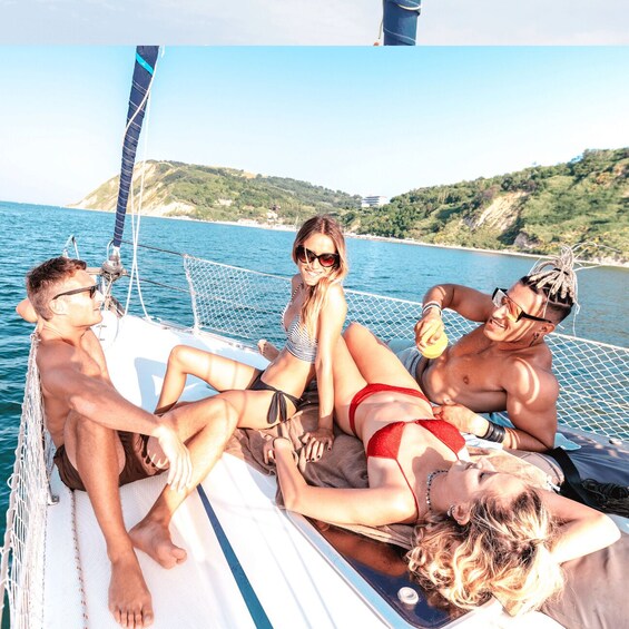 A group of people relaxing on a boat with a scenic coastal landscape in the background. 1
