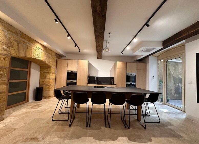A modern kitchen with a large island, wooden cabinets, and a stone wall. 4
