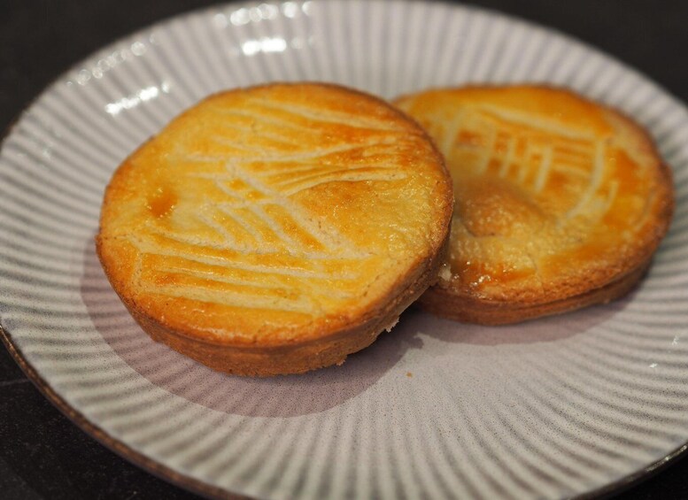 Two round pastries with a golden-brown crust on a speckled ceramic plate. 3