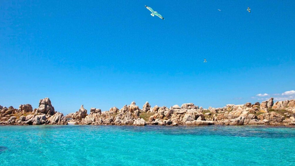 A coastal landscape with clear turquoise waters and rocky formations. 2