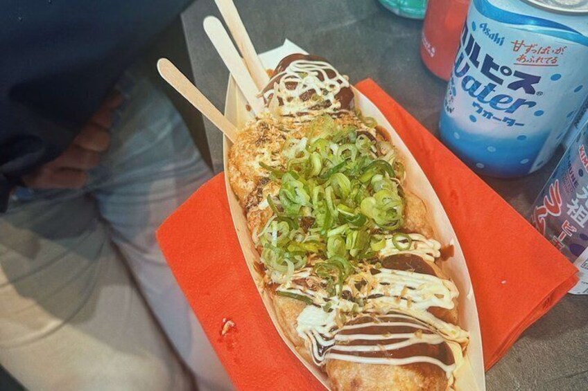 A food item with a white sauce, green toppings, and a blue can in the background. 3