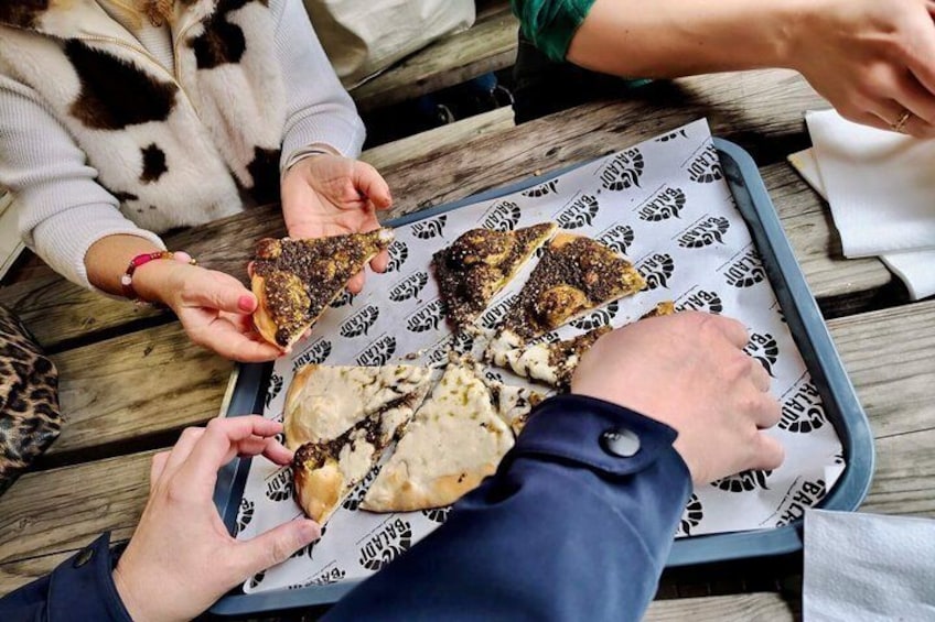 People sharing food on a wooden table. 1