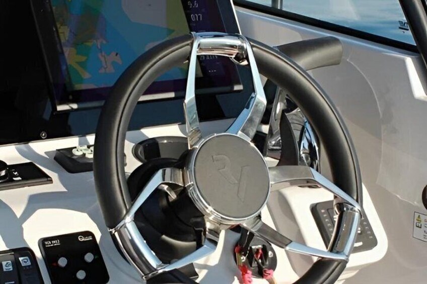 A boat's steering wheel with a logo, a control panel, and a map display. 4