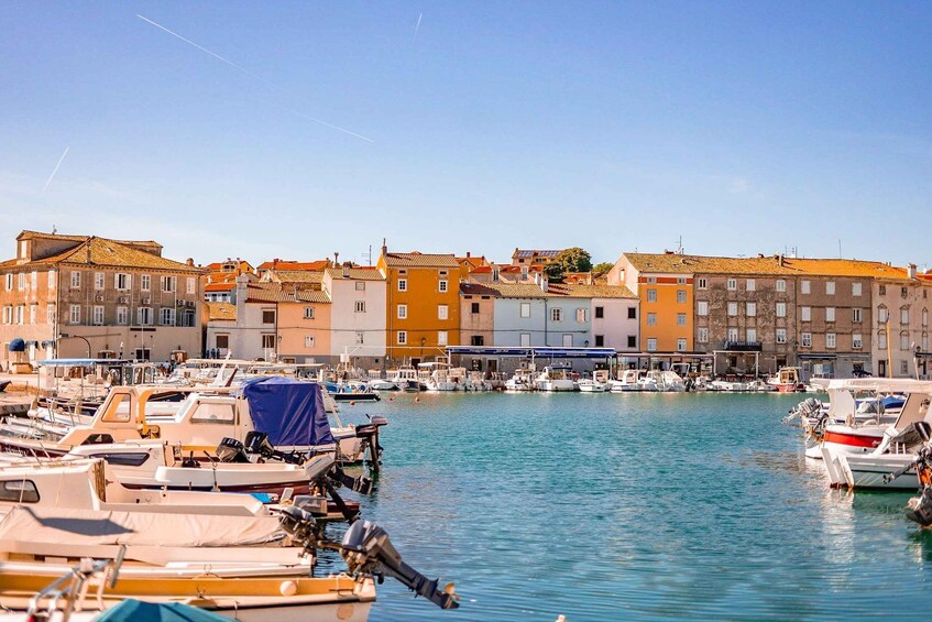 A marina with boats docked, buildings in the background, and a clear sky. 5