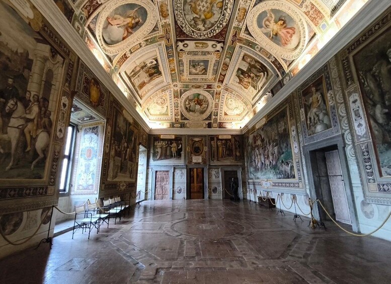 A grand hall with ornate frescoes, a high ceiling, and classical architecture. 2