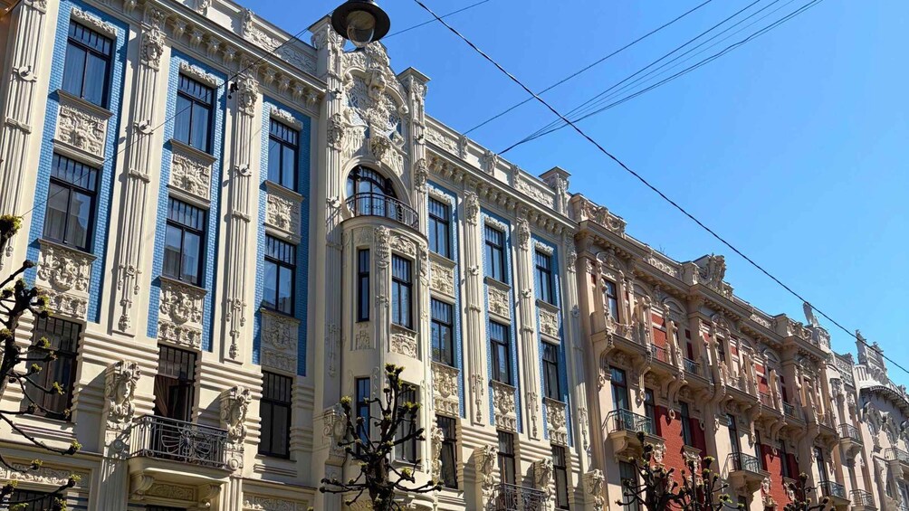 A row of ornate buildings with classical architecture, featuring detailed facades and large windows. 4