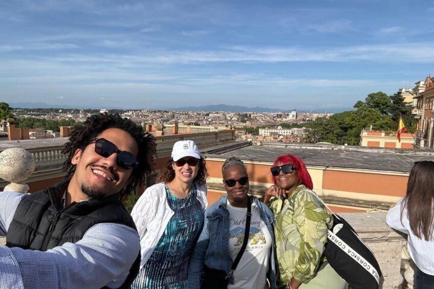 A group of people on a rooftop with a cityscape in the background. 3