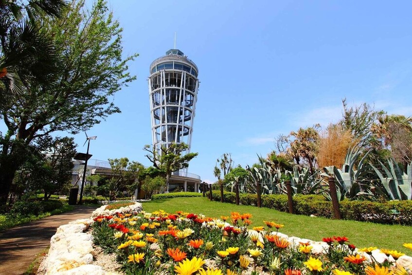 A tower, a garden with colorful flowers, and a clear blue sky. 4