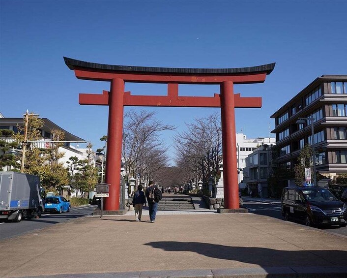 A red torii gate in an urban setting with buildings and a clear sky. 2
