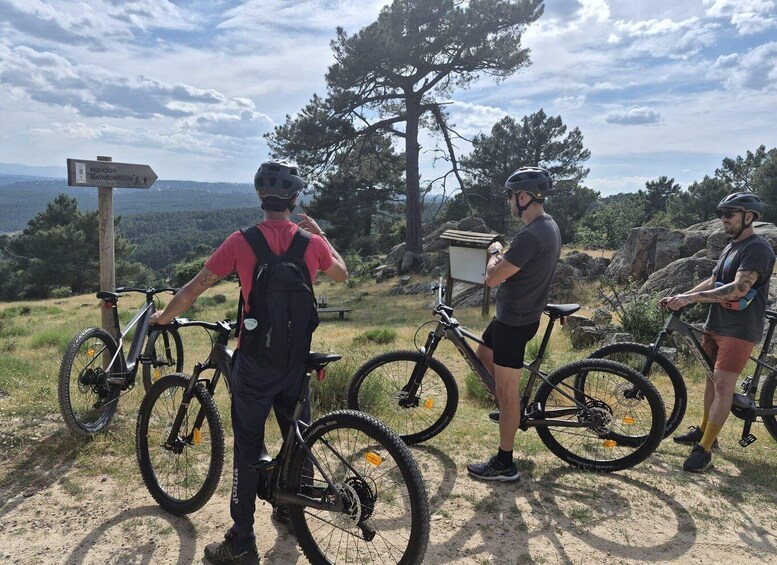 Three cyclists on a mountain trail with a sign indicating the direction to Mirador Mataborricos. 5