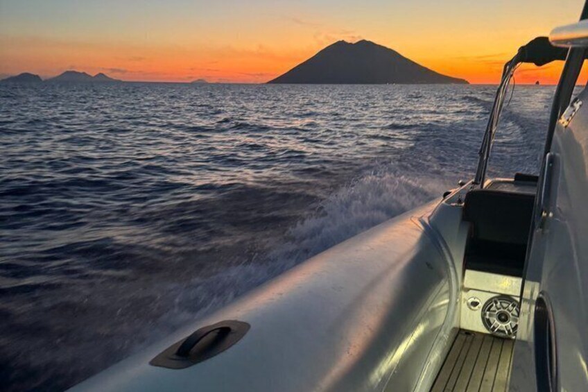 A boat on water with a sunset and a mountain in the background. 5