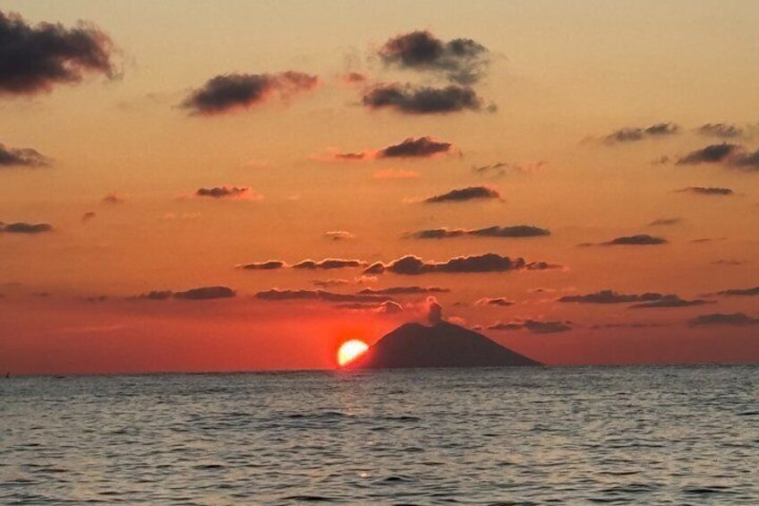A sunset over the ocean with a mountain silhouette. 2