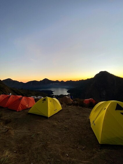 A campsite with tents and a lake in the background. 5