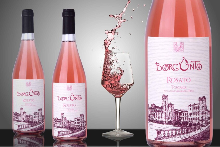 Three bottles of Borg'Unto Rosato wine with a splash of wine in a glass. 3