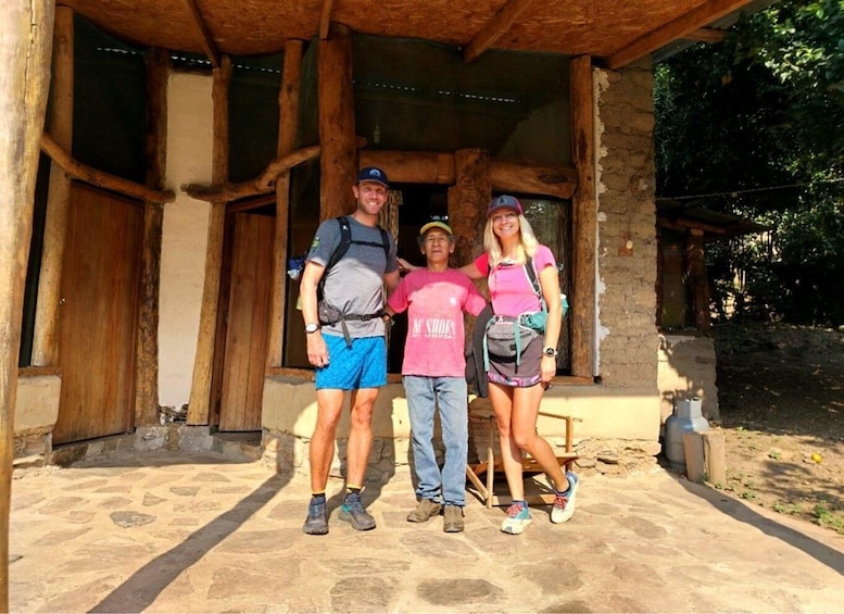 A rustic stone building with wooden beams, a stone-paved entrance, and a wooden bench outside. 4