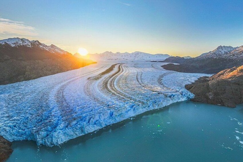 A glacier with a river flowing through it, surrounded by mountains. 5