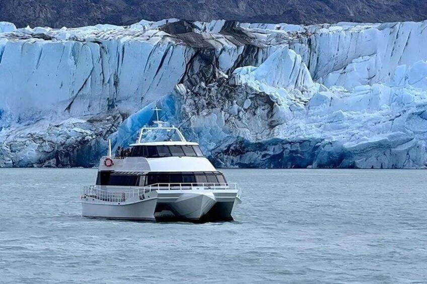 A boat on calm waters with a glacier in the background. 4