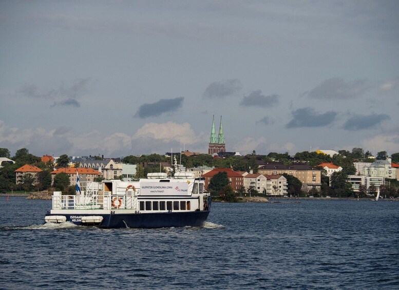 A ferry named 'ISOSAAR HELSIN' on a body of water with a cityscape in the background, including a prominent church spire. 5