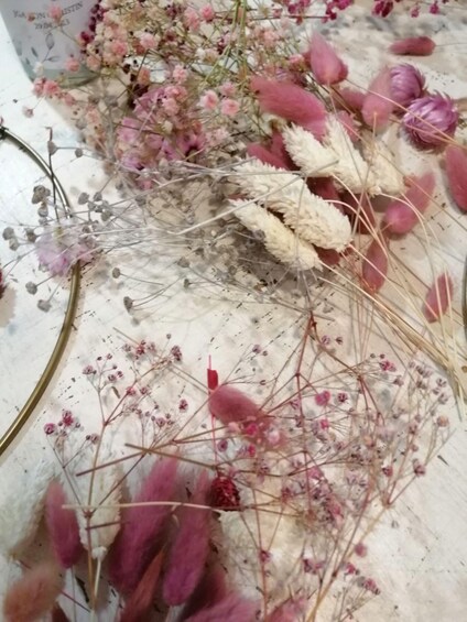 A collection of dried flowers and plants on a white surface. 4