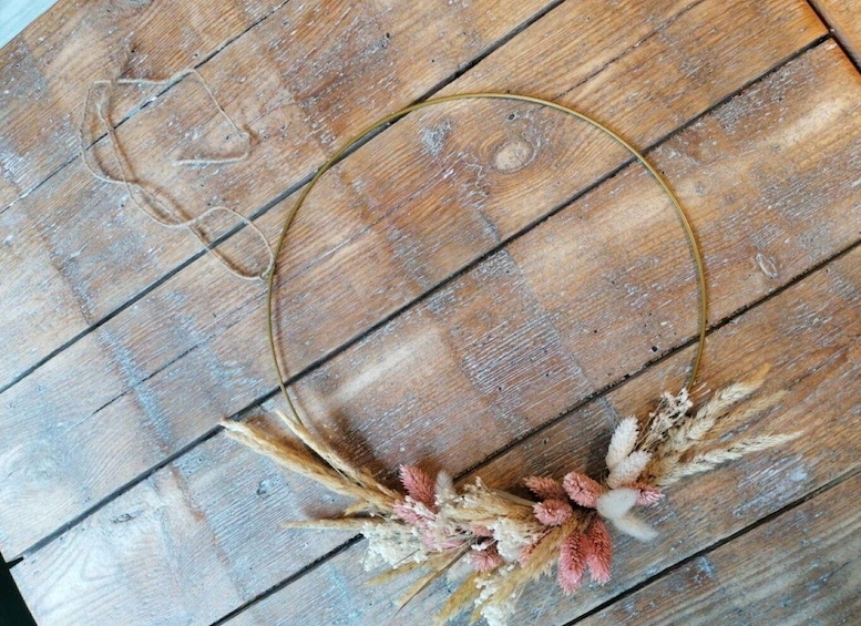 A rustic wooden surface with a circular object and dried wheat stalks. 5