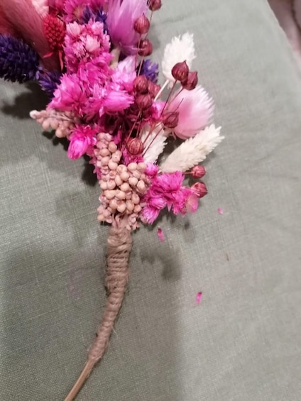 A bouquet of flowers with pink, purple, and white petals, and a brown stem. 2