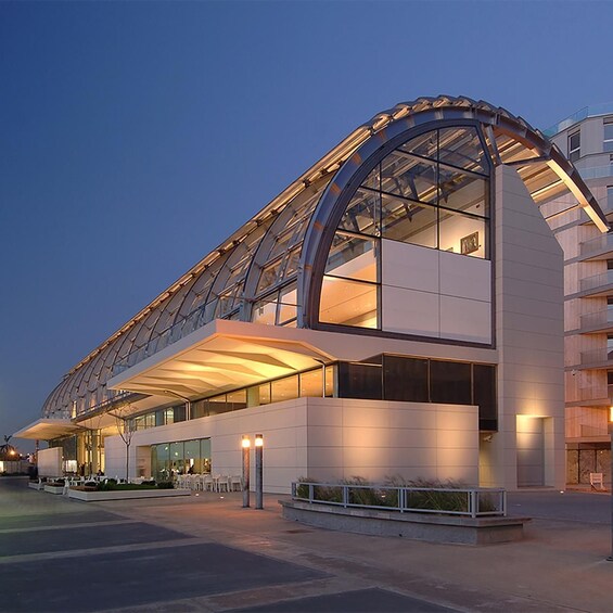 A modern building with a curved glass facade and a flat roof. 1