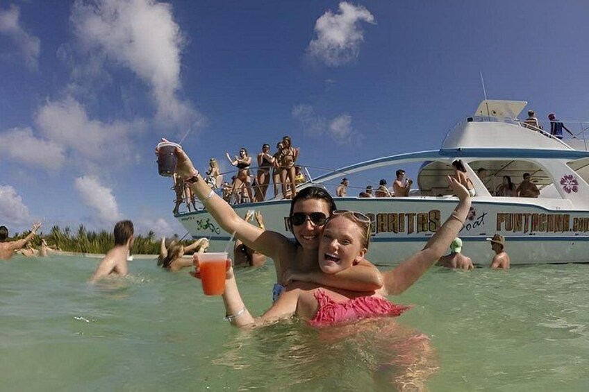 A group of people on a boat with a tropical setting in the background. 3