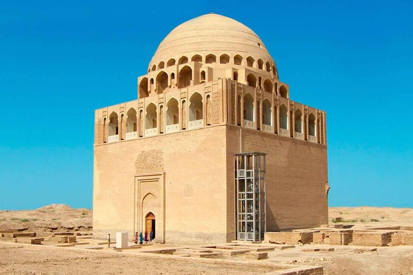 A large, beige dome structure with arched windows and a central entrance, surrounded by a desert landscape. 4