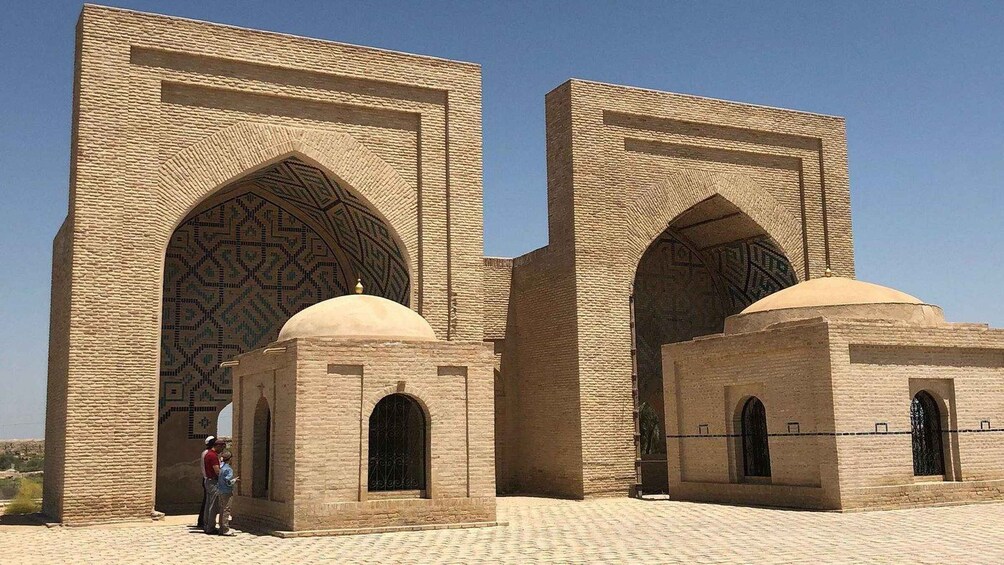 A historic building with large arched doorways and domed structures. 5
