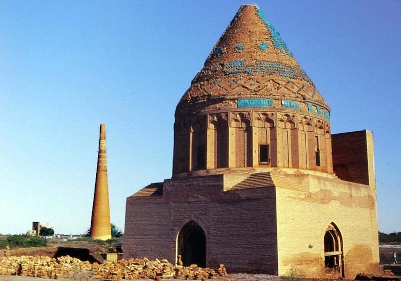 A historic building with a conical roof and a tall, slender minaret. 1