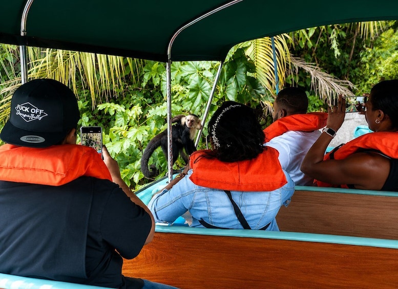People on a boat with a monkey on the side. 2