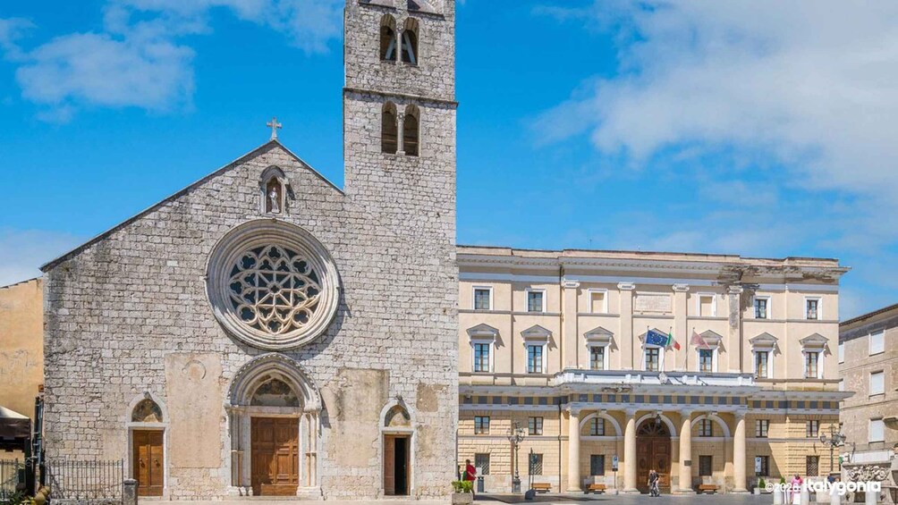 A historic church with a tall bell tower and a large circular stained glass window, and a classical building with multiple arches and flags. 3