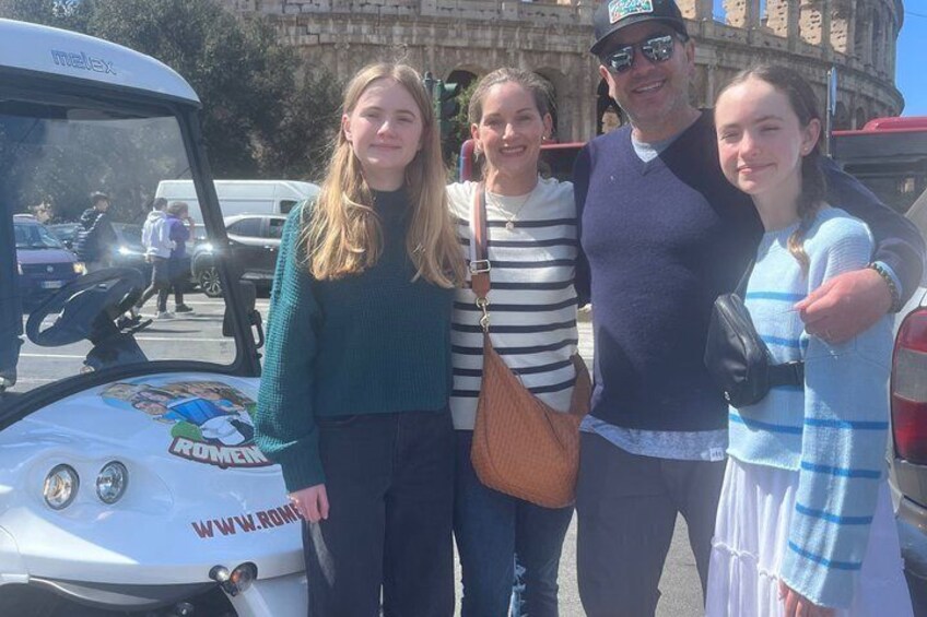 A group of people standing in front of a white vehicle with 'ROMEN' and a website on it. 4