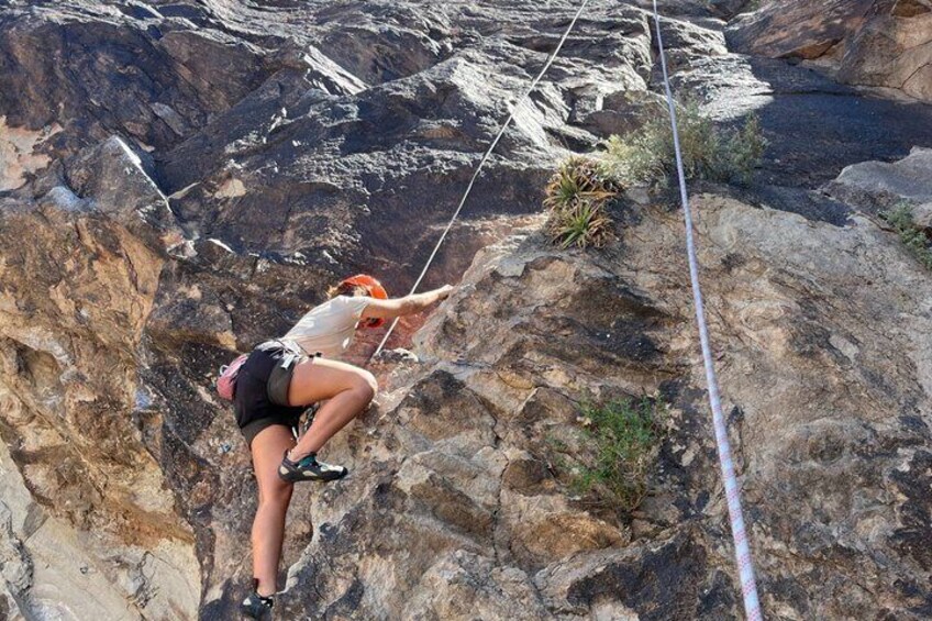 A person rock climbing on a rocky cliff. 3