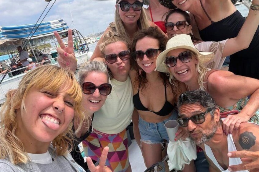 A group of people on a boat with a clear sky and calm water. 5