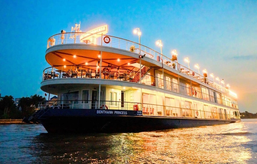 A riverboat named 'Benthanh Princess' with multiple decks and lights, docked at night. 1