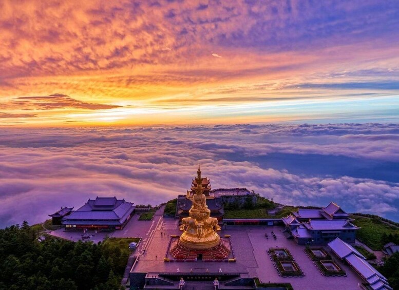 A golden statue surrounded by traditional buildings, set against a backdrop of clouds and a colorful sky. 1