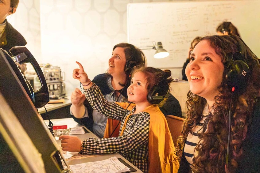 A group of people in a room with a whiteboard and a computer. 1