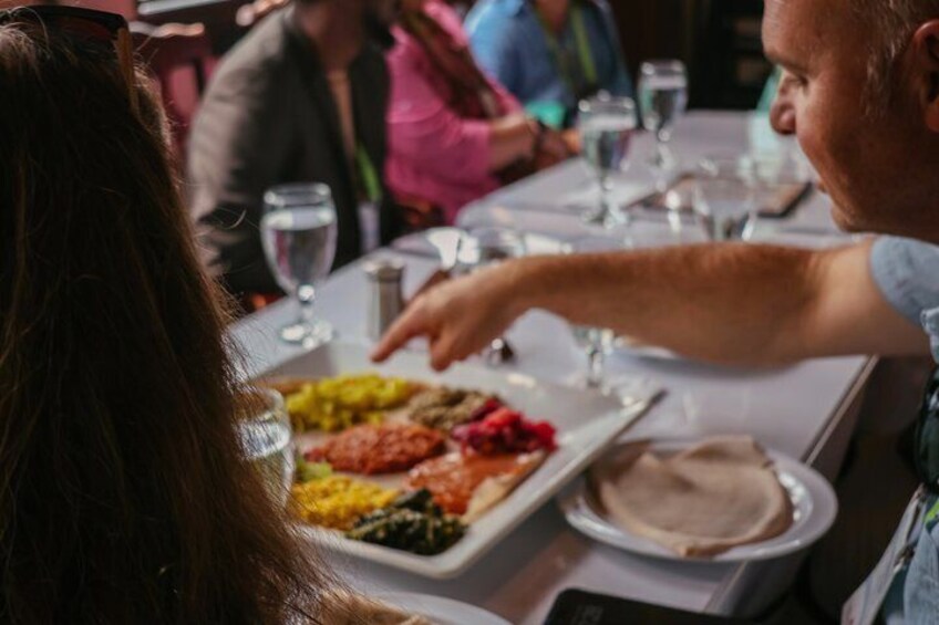 A group of people dining at a restaurant with various dishes on the table. 1