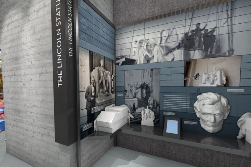 A museum exhibit with Lincoln statues and historical photographs. 1
