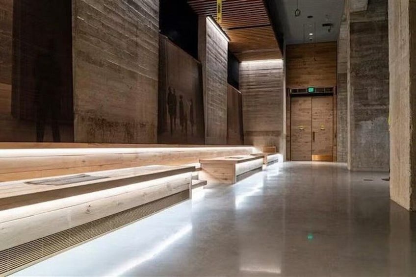 A modern interior with wooden benches, a polished floor, and a wooden door in the background. 4