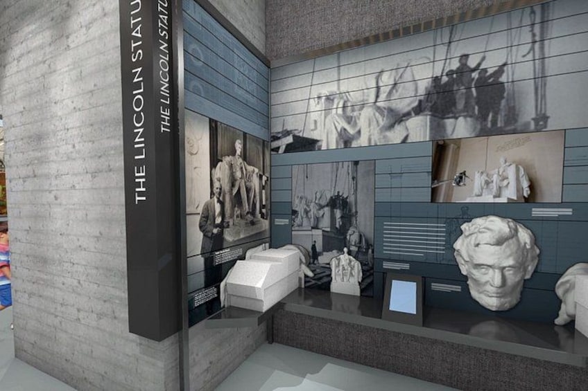 A museum exhibit with Lincoln statues and historical photographs. 1