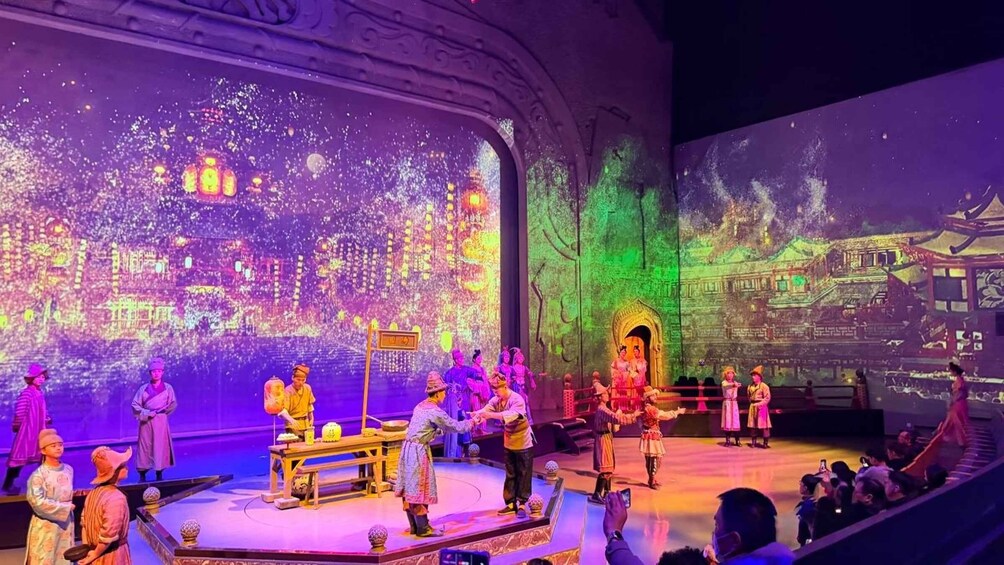 A stage performance with actors in traditional costumes, a large backdrop depicting a cityscape, and an audience seated in front. 4