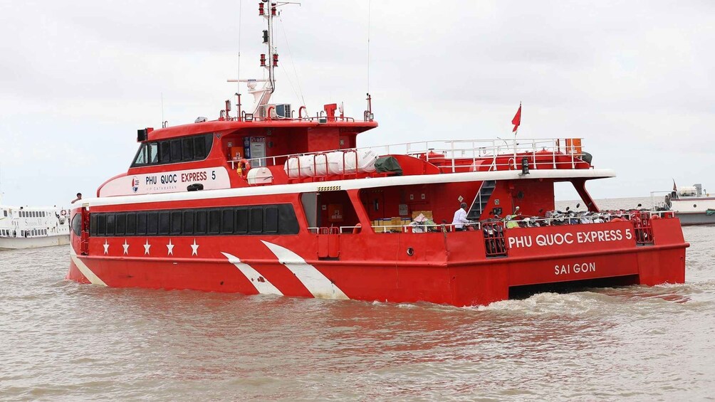 A red ferry named PHU QUOC EXPRESS 5 with 'VIP CATARAN' written on the side, sailing on water. 5
