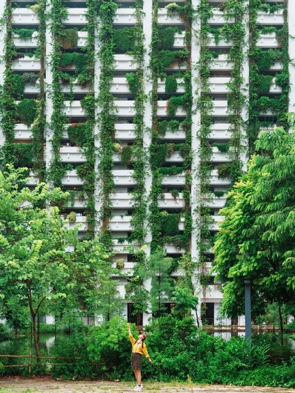 A person playing badminton in front of a building with vertical gardens. 3