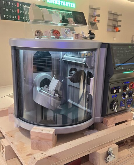 A large industrial machine with a control panel, placed on a wooden platform. 5